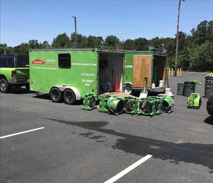 A SERVPRO truck and trailer unloading equipment at a large commercial water disaster